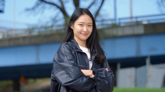 Woman standing with arms crossed and smiling
