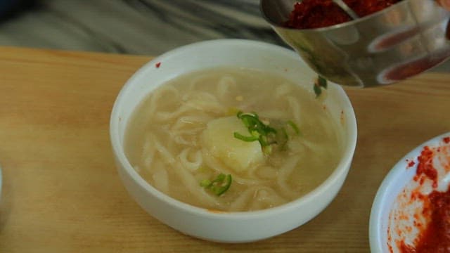 Adding marinade to the chicken soup with noodles