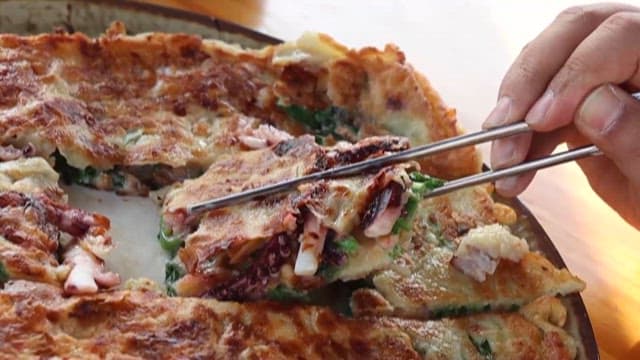 Seafood and green onion pancakes picked with chopsticks