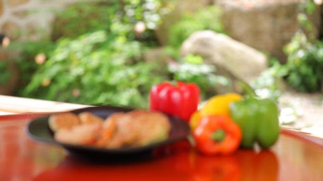 Plate of meatballs plated with various colored bell peppers