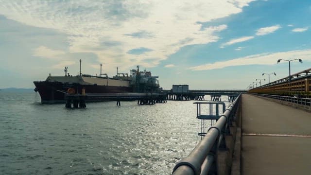 A large cargo ship docked at an industrial port on a sunny day