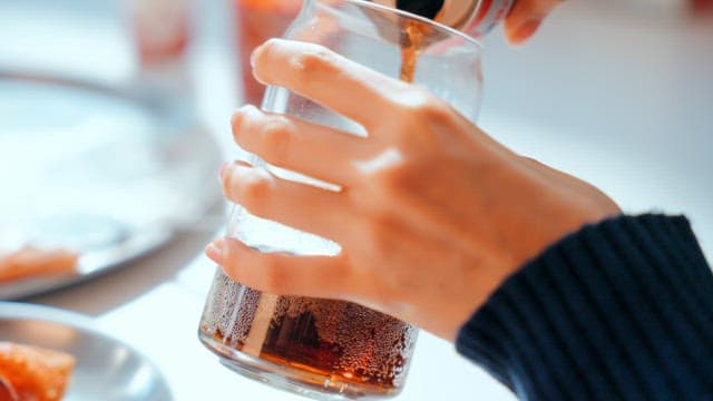 Pouring cola into a glass