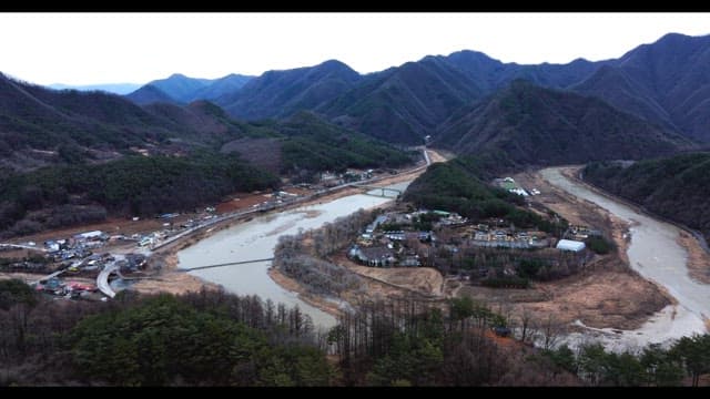 Small town surrounded by mountains and rivers on a cloudy day