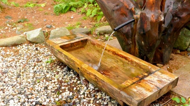 Water flowing into a wooden trough at mineral spring