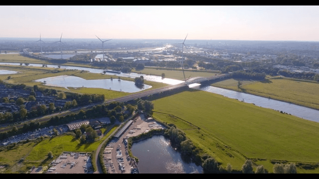 Scenic view of a river with wind turbines