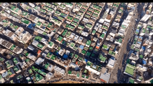 Aerial view of a city with green rooftops