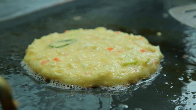 Crispy and savory mung bean pancakes grilled on an iron plate