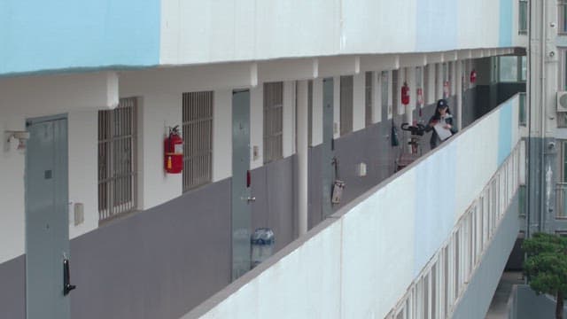 Woman walking around the hallways of the apartment attaching flyers