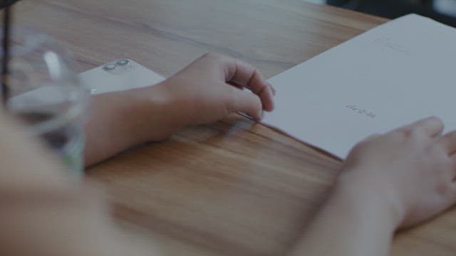 Paper documents and cell phone on a wooden table
