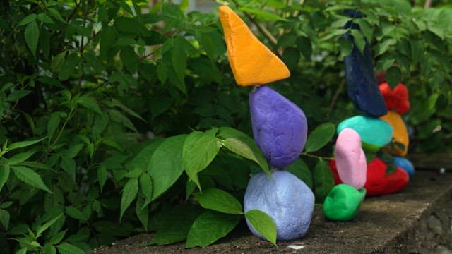 Colorful painted rocks stacked in garden