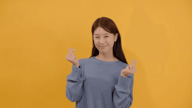 Woman giving finger hearts with happy expression