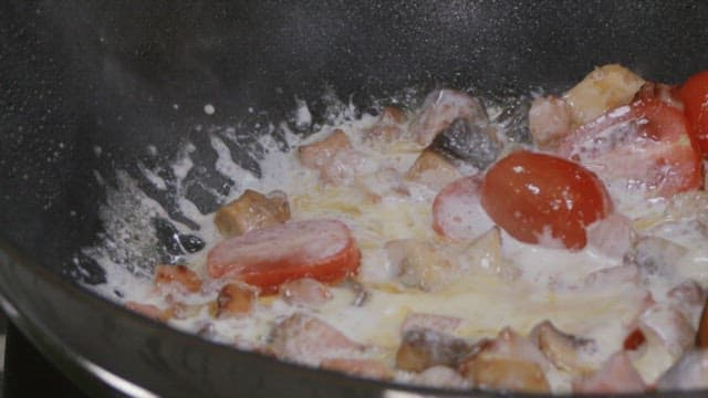 Cooking a delicious creamy dish with tomatoes and mushrooms