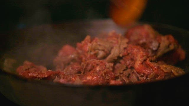 Cooking beef bulgogi stir-fry in a frying pan with a wooden spatula