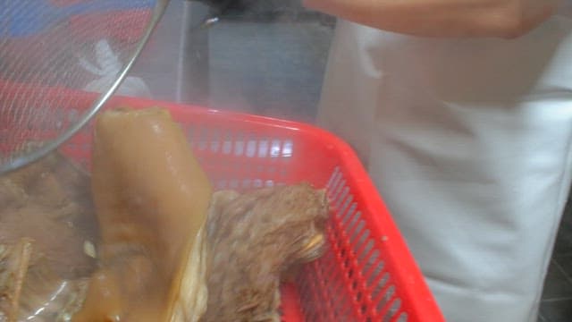 Rinsing boiled pig's feet in water in the kitchen