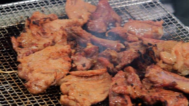 Grilling marinated pork ribs on a charcoal grill