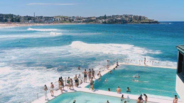 Coastal Leisure Scene with Ocean Pool and Beachgoers