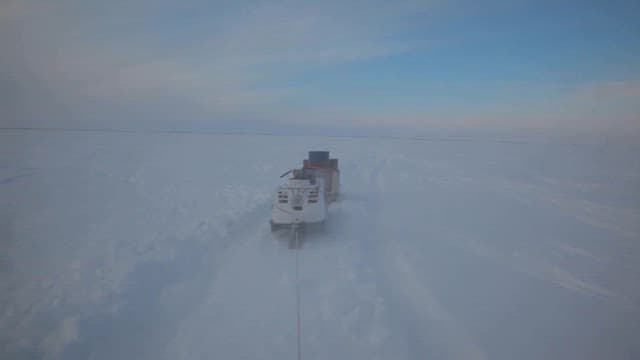 Snowmobile Travelling Across Snowy Landscape