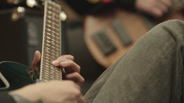 People playing the guitar indoors