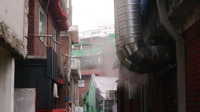 Residential alley with steam-belching pipes