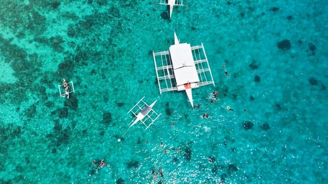 Boats floating on clear turquoise water