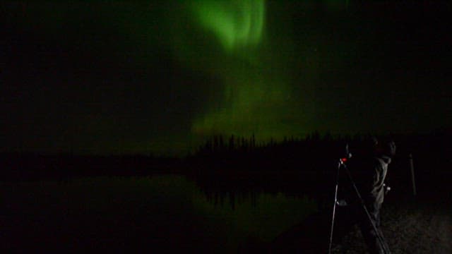 Person who photographs the aurora in the night sky