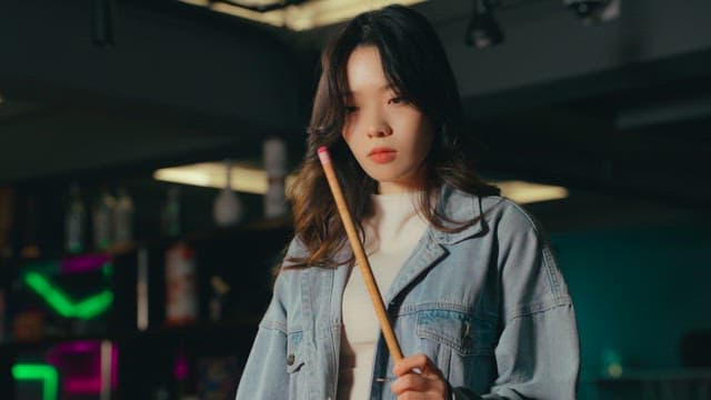 Person Putting Chalk on a Billiard Cue Stick