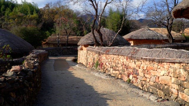 Rustic thatched-roof village road in the countryside bathed in sunlight
