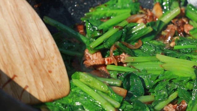 Stir-fry pork and fresh young radish leaves in a pan