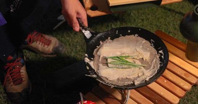 Preparing Vegetable Pancakes Outdoors at Night during Camping