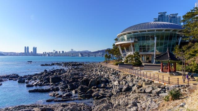 Sky from day to night as seen from a rocky shore with an observation deck