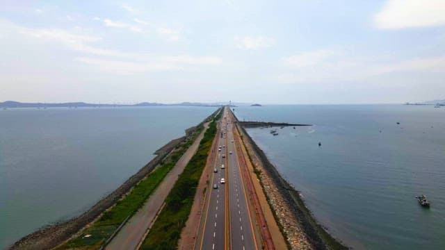 Long coastal road with cars driving