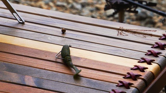 Man preparing fishing bait on a wooden table