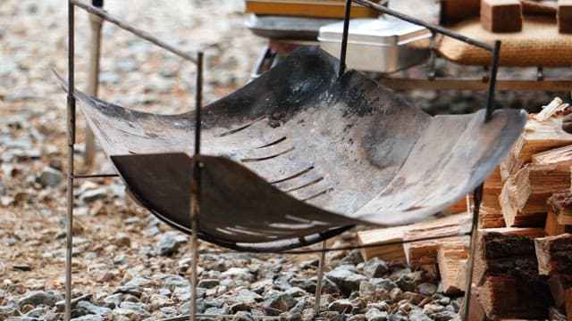 Preparing to light a fire in the brazier on the gravel