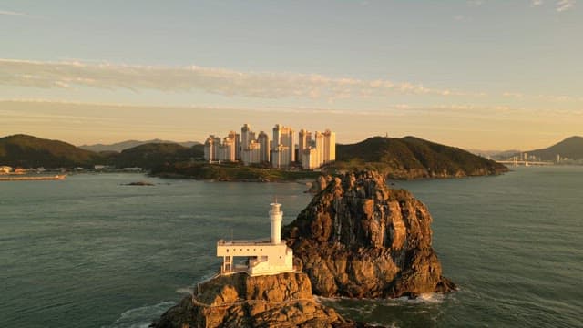 Lighthouse and city skyline at sunset