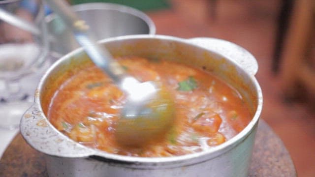 Hearty octopus stew in a metal pot