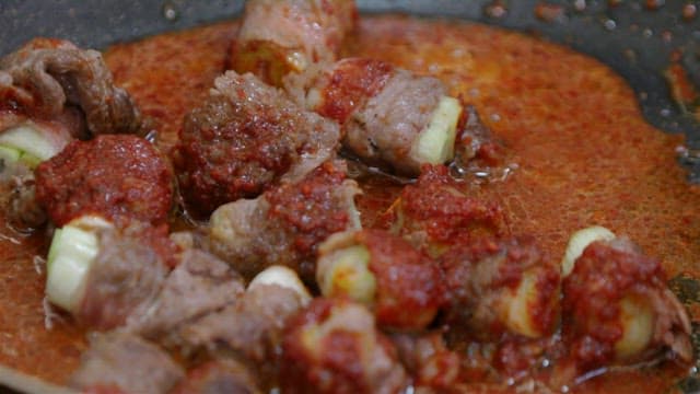 Green onion beef rolls cooking in a pan