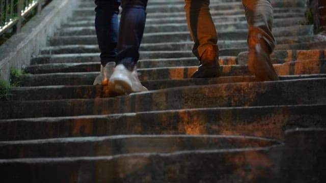 Two People Walking Up Stairs at Night