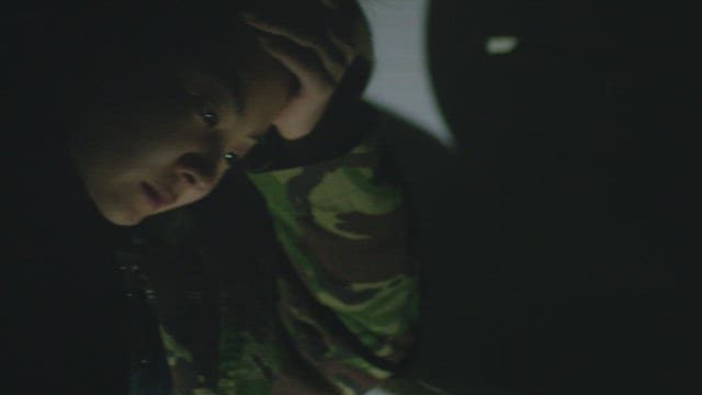 Woman runnung her hand through her hair with a serious face in a dark room