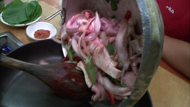 Prepared eel and vegetables poured into a pan
