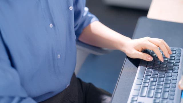 Person typing on a keyboard in an office