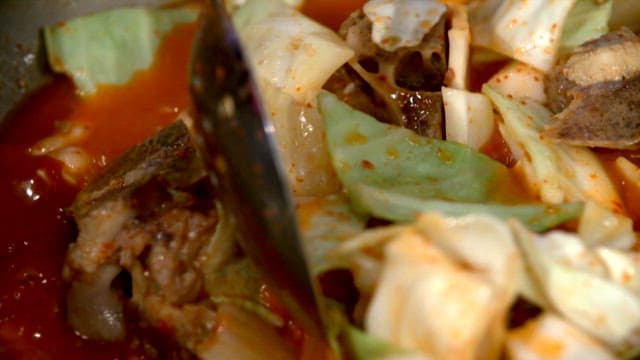 The process of cooking food with vegetables and meat in red soup