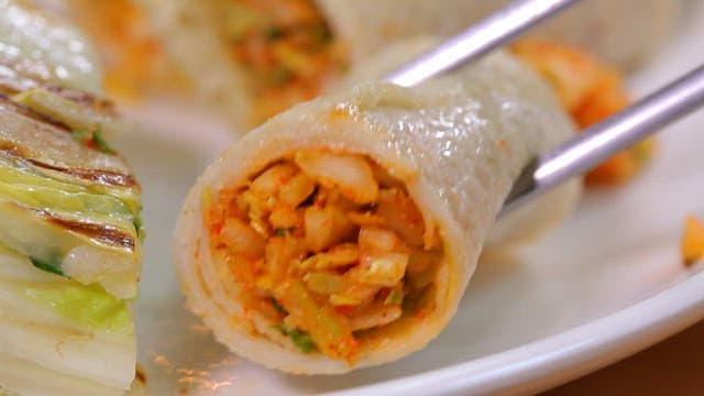 Buckwheat crepe with cabbage filling held with chopsticks