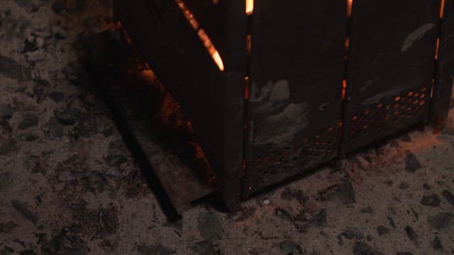 Flames dancing in a metal fire pit at night