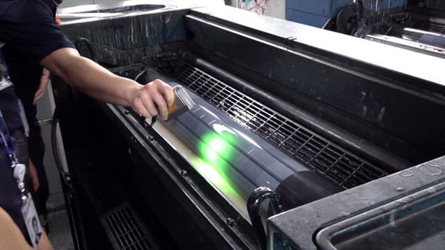 UV lamp shines on a large industrial fluorescent ink printer