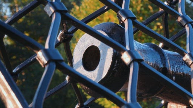 Metal cannon displayed outdoors with sunlight