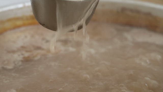 Pouring Broth into a Pot while Cooking