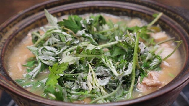 Pork soup with fresh mugwort boiling in a pot
