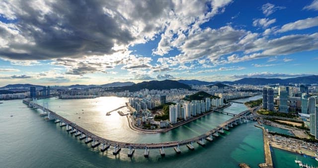 Evening view of the busy port city Busan with a cloudy sky and Gwangan Bridge