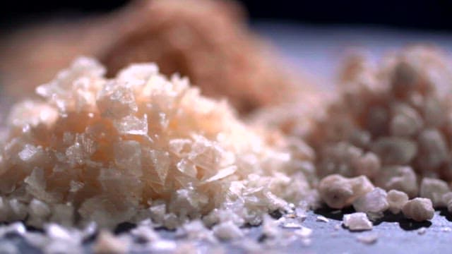 Close-up of different types of salt crystals on a flat surface