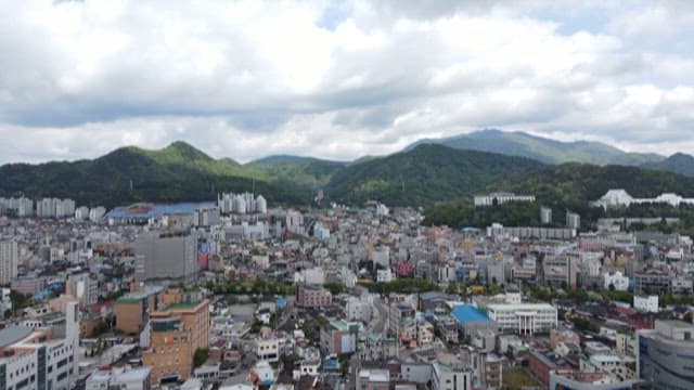 Dense Cityscape with Surrounding Mountains on a Cloudy Day